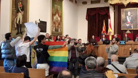Tres jóvenes despliegan banderas del colectivo LGTBIQ+ durante el pleno del Ayuntamiento de Elche. Tres jóvenes despliegan banderas del colectivo LGTBIQ+ durante el pleno del Ayuntamiento de Elche.