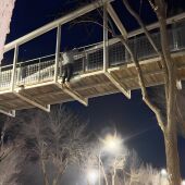 Joven haciendo dominadas colgado de un puente en La Solana