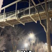 Imagen del joven colgado del puente haciendo dominadas