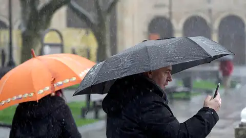Viandantes se refugian de la lluvia bajo los paraguas Viandantes se refugian de la lluvia bajo los paraguas