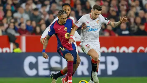 El delantero del Barcelona Raphinha (i) pelea un balón con Saúl Ñíguez, del Sevilla, durante el partido de LaLiga de fútbol que Sevilla FC y FC Barcelona han disputado este domingo en el estadio Ramón Sánchez-Pizjuán El delantero del Barcelona Raphinha (i) pelea un balón con Saúl Ñíguez, del Sevilla, durante el partido de LaLiga de fútbol que Sevilla FC y FC Barcelona han disputado este domingo en el estadio Ramón Sánchez-Pizjuán