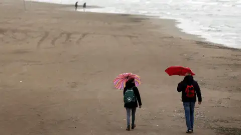 Dos personas pasean por la playa de la Malvarrosa, en València Dos personas pasean por la playa de la Malvarrosa, en València