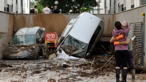 Dos vecinos se abrazan a la entrada de un garaje en Paiporta, Valencia, tras el paso de la dana. Dos vecinos se abrazan a la entrada de un garaje en Paiporta, Valencia, tras el paso de la dana.