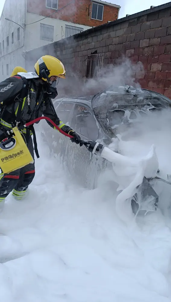 Un bombero apaga el incendio de un vehículo Un bombero apaga el incendio de un vehículo
