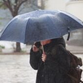 Una persona lleva paraguas por la lluvia.