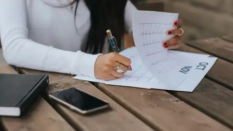 Una persona apuntando algo en un calendario Una persona apuntando algo en un calendario
