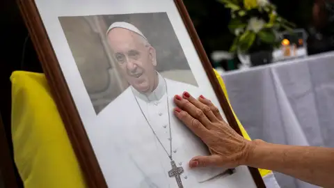 Fieles rezan junto a una imagen del papa Francisco. Fieles rezan junto a una imagen del papa Francisco.