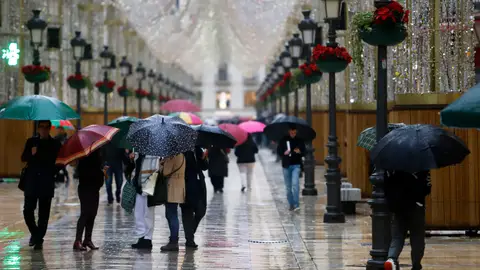 Gente con paraguas en una calle de Málaga Gente con paraguas en una calle de Málaga