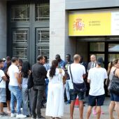 Persones migrants fent cua en una seu de la delegació del Govern d'Espanya per renovar el NIE