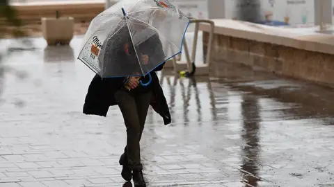 Una persona se resguarda con un paraguas de la lluvia en Almería. Una persona se resguarda con un paraguas de la lluvia en Almería.