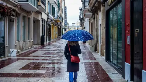 Una mujer con paraguas se protege de la lluvia. Una mujer con paraguas se protege de la lluvia.