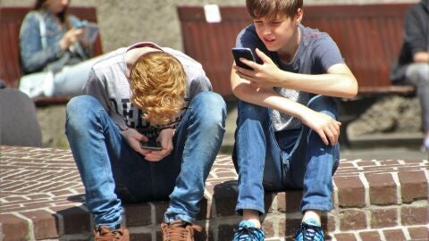Adolescents mirant els seus telèfons mòbils Adolescents mirant els seus telèfons mòbils