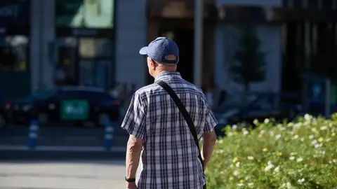 Un señor mayor camina por una calle de Madrid. Un señor mayor camina por una calle de Madrid.