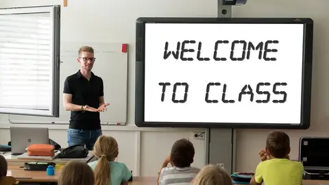 Todo lo que debes saber para ser maestro en Canarias Profesor dando la bienvenida a clase a sus alumnos