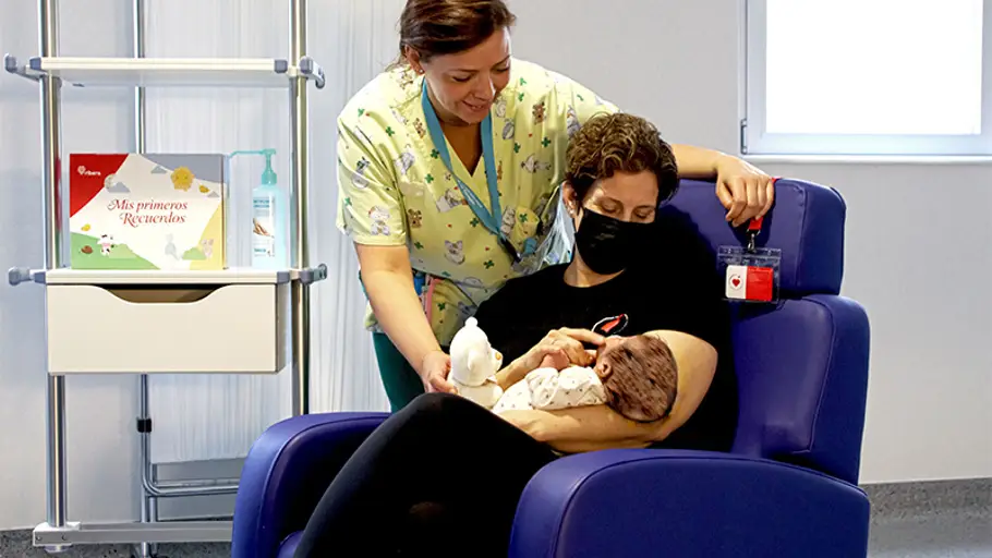 El Hospital Universitario de Torrejón y Mamás en Acción colaborar para desarrollar un programa de acompañamiento a menores vulnerables durante su hospitalización Una voluntaria de Mamás en Acción con un bebé durante su labor de acompañamiento en un centro hospitalario