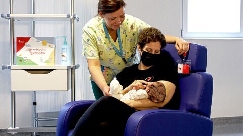 Una voluntaria de Mam&aacute;s en Acci&oacute;n con un beb&eacute; durante su labor de acompa&ntilde;amiento en un centro hospitalario