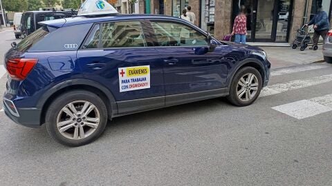 Un coche de una autoescuela en Elche con el cartel que visibiliza la protesta.