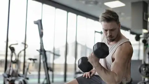 Un hombre levantando pesas en el gimnasio Un hombre levantando pesas en el gimnasio
