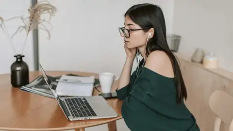 Una chica teletrabajando en el salón de su casa Una chica teletrabajando en el salón de su casa