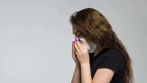 Imagen de recurso. Mujer sonándose la nariz con un pañuelo Imagen de recurso. Mujer sonándose la nariz con un pañuelo