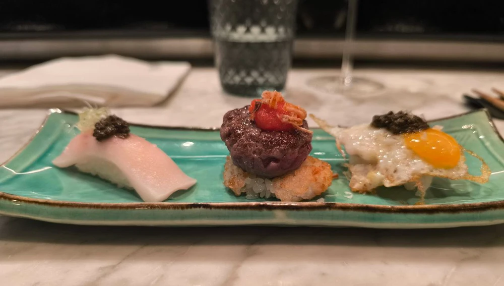 La triada de nigiris de huevo frito con trufa, arroz frito y hamburguesa de 'wagyu' y de lubina y trufa. La triada de nigiris de huevo frito con trufa, arroz frito y hamburguesa de 'wagyu' y de lubina y trufa.