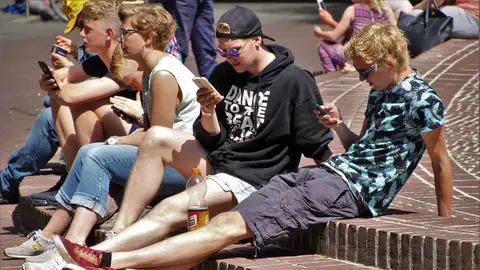 Jóvenes mirando teléfono móvil Jóvenes mirando teléfono móvil