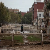 Un vecino de Aldaia cruza el barranco que se desbordó en el municipio. Un vecino de Aldaia cruza el barranco que se desbordó en el municipio.