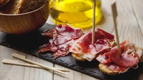 El momento más saludable para cenar, según los expertos Tapa de jamón, pan y aceite
