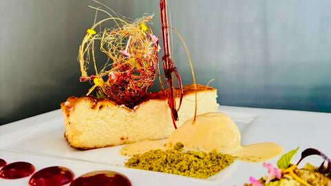 Tarta de queso de cabra el abuelo tierra de chocolate y pistachos, compota de frutos rojos y helado de licor. 