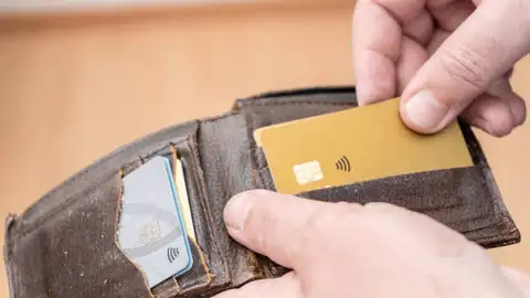 Los hogares españoles se gastaron un tercio de su presupuesto en el hogar en 2024 Persona sujetando su tarjeta bancaria