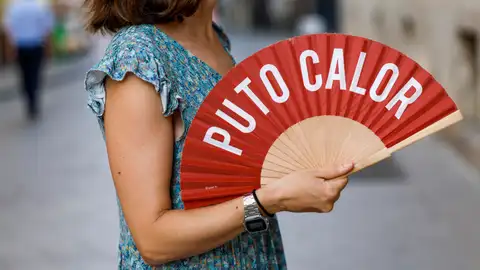 Imagen de archivo de una mujer combatiendo el calor con un abanico en la Comunitat Valenciana Imagen de archivo de una mujer combatiendo el calor con un abanico en la Comunitat Valenciana