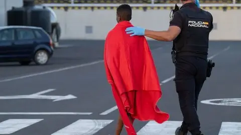 Un agente atiende a un inmigrante llegado a Canarias Un agente atiende a un inmigrante llegado a Canarias