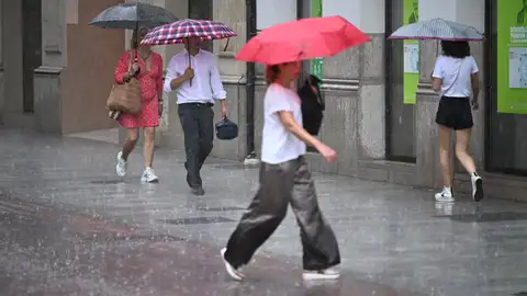 Varias personas caminan por una calle de Castellón bajo una intensa lluvia. Varias personas caminan por una calle de Castellón bajo una intensa lluvia.