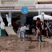 Empleats de locals de restauració del passeig marítim de Cubelles netegen els desperfectes fruit del desbordament de Foix