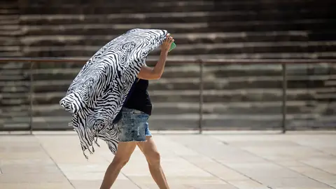 Una persona se cubre del sol mientras camina por el centro de Málaga Varias provincias en alerta por calor extremo: temperaturas de hasta 39 grados en estas zonas