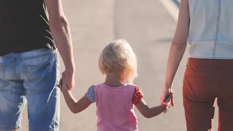 Imagen de archivo de una niña con sus padres. Imagen de archivo de una niña con sus padres.