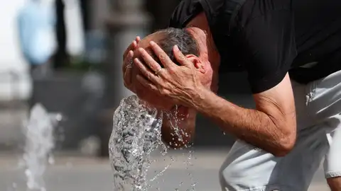 Un hombre se refresca en una fuente en Córdoba Un hombre se refresca en una fuente en Córdoba