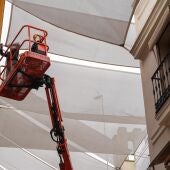 Archivo - Archivo-Un operario coloca toldos en la calle Sierpes. - María José López - Europa Press - Archivo