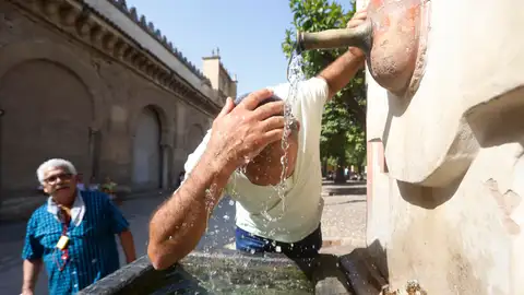 Un turista se echa agua en la cabeza de una fuente en el Patio de los Naranjos de la Mezquita Catedral de Córdoba. Un turista se echa agua en la cabeza de una fuente en el Patio de los Naranjos de la Mezquita Catedral de Córdoba.
