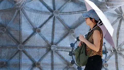 Una persona se protege del sol con un paraguas. Una persona se protege del sol con un paraguas.