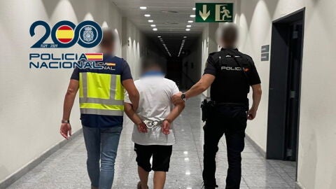 Agentes de la Polic&iacute;a Nacional con el detenido en el aeropuerto Alicante-Elche.