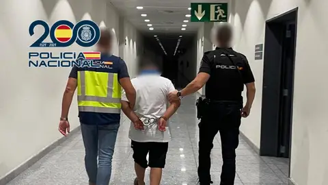 Agentes de la Policía Nacional con el detenido en el aeropuerto Alicante-Elche. Agentes de la Policía Nacional con el detenido en el aeropuerto Alicante-Elche.