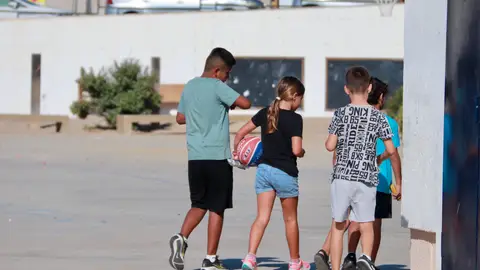 Nens i nenes jugant al pati d'una escola Nens i nenes jugant al pati d'una escola