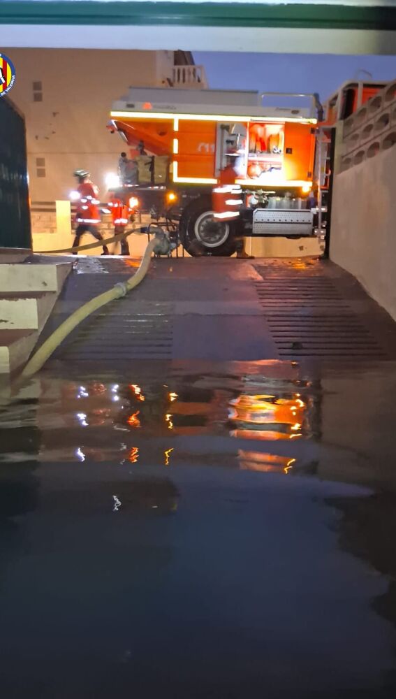 Los bomberos trabajan en una garaje anegado en el Mareny