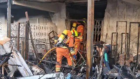 Dos bomberos revisan una de las viviendas a la que ha afectado el fuego. Dos bomberos revisan una de las viviendas a la que ha afectado el fuego.