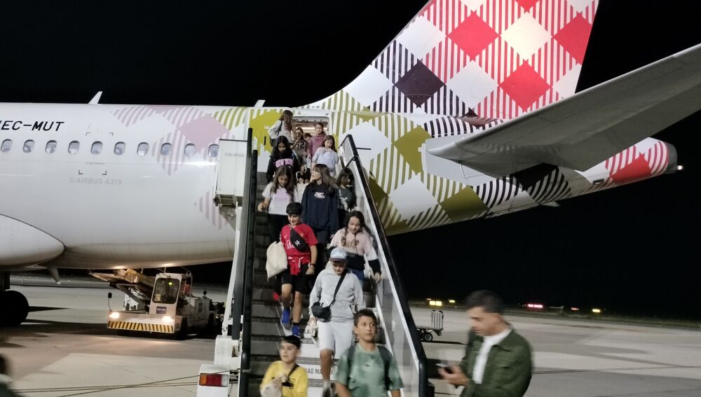 Los alumnos descienden por la escalinata del avión tras un día repleto de emociones.