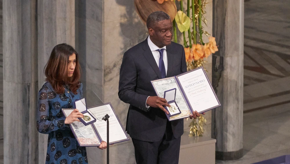 El Dr. Denis Mukwege y Nadia Murad posan en el escenario tras recibir el Premio Nobel de la Paz 2018 en el Ayuntamiento de Oslo, Noruega El Dr. Denis Mukwege y Nadia Murad posan en el escenario tras recibir el Premio Nobel de la Paz 2018 en el Ayuntamiento de Oslo, Noruega