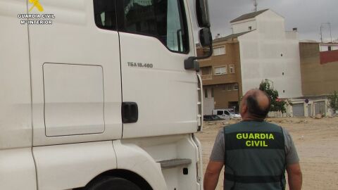 Un agente de la Guardia Civil junto a la cabeza tractora del cami&oacute;n que se ha podido recuperar tras ser robada.