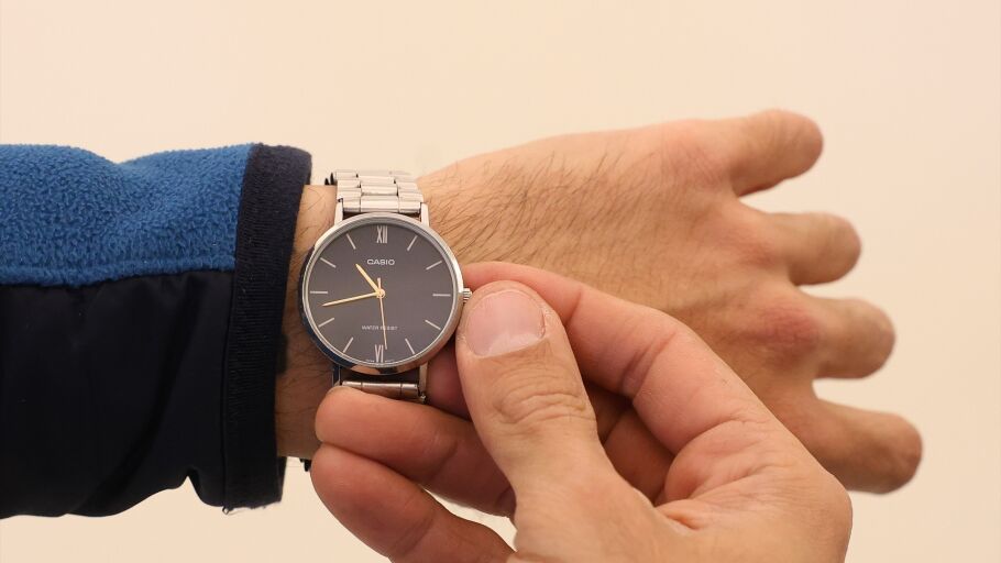 Un hombre cambia la hora en su reloj