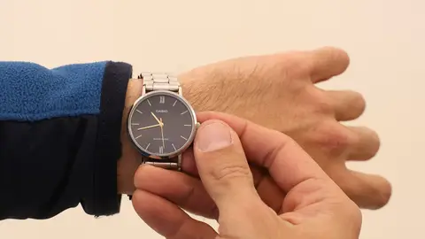 Un hombre cambia la hora en su reloj Un hombre cambia la hora en su reloj